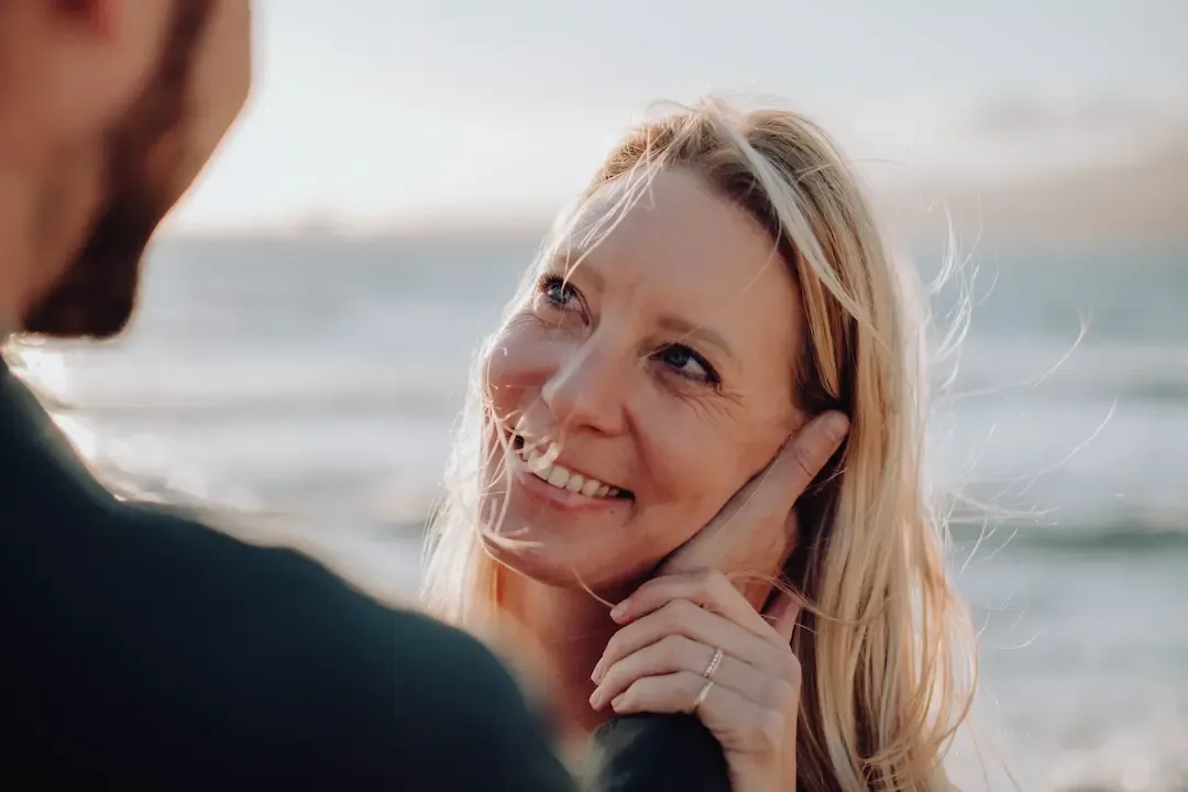 Nadine Kleifges lächelt ihren Partner am Meer an