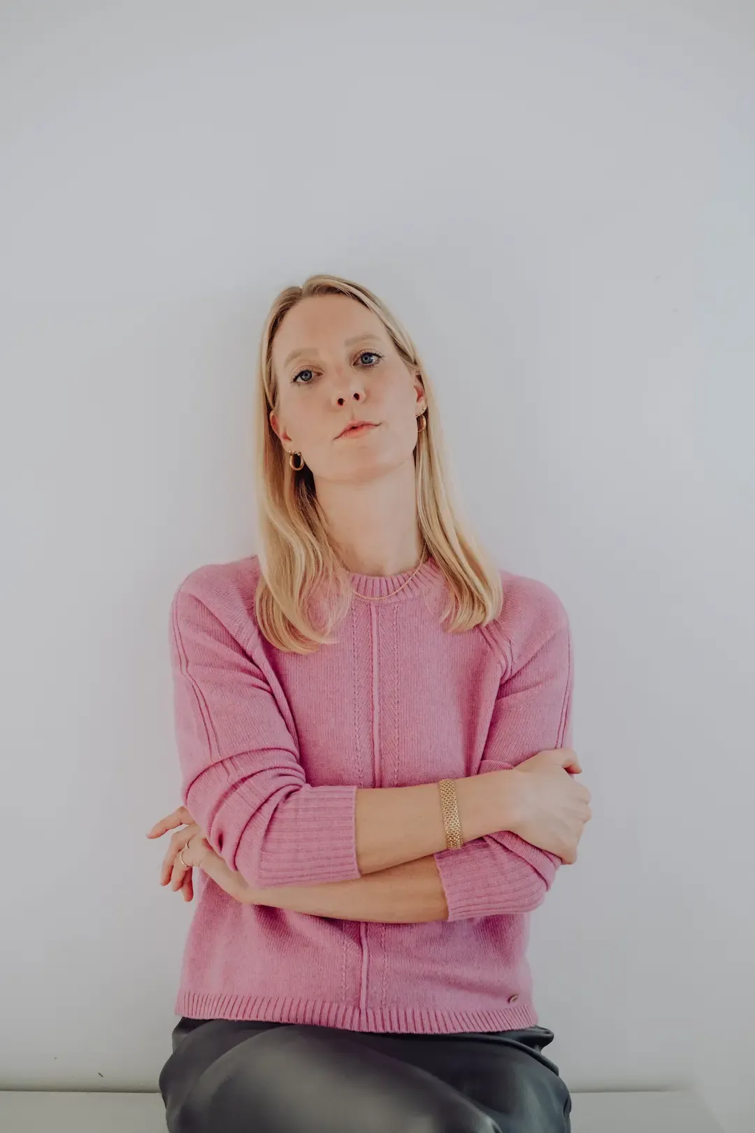 Nadine Kleifges im rosa Pullover vor heller Wand